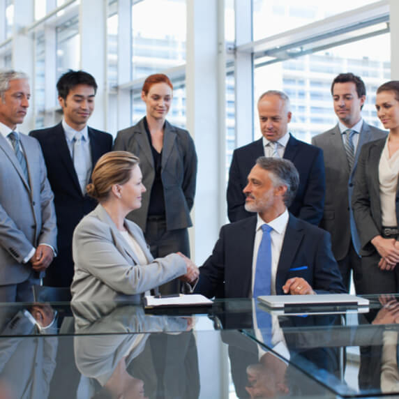 a group of people standing around a table